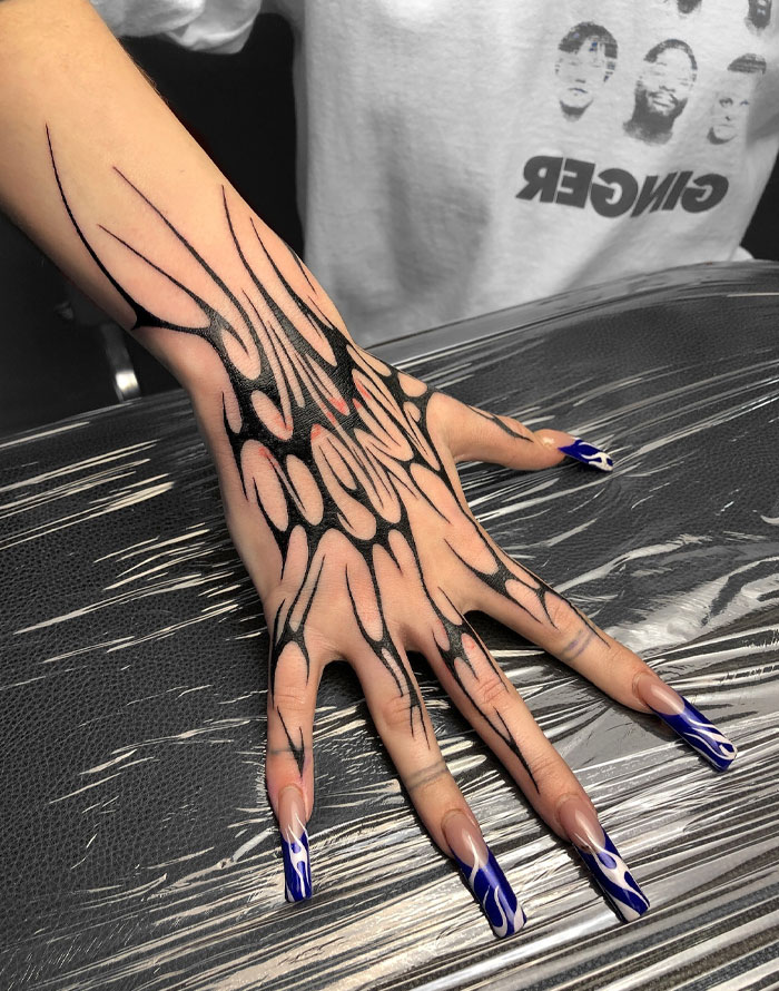 Woman's tattooed hand with long nails